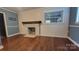 Cozy living room features shiplap walls, brick fireplace with wood mantle, and hardwood floors at 8282 Park Edwards Rd, Kannapolis, NC 28081