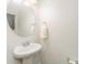 Bathroom with a white pedestal sink, round mirror, and a towel rack at 829 River Park Rd, Belmont, NC 28012