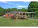 Exterior view of the back of a brick home with a covered patio and mature trees at 1000 Peachtree Rd, Charlotte, NC 28216