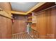 Unfinished basement area featuring wood paneled walls and shelving at 1000 Peachtree Rd, Charlotte, NC 28216