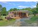 Charming brick home featuring a covered carport and inviting front porch with wood detail at 1000 Peachtree Rd, Charlotte, NC 28216