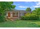 Charming single-story brick home featuring a cozy front porch and well-maintained landscaping at 1000 Peachtree Rd, Charlotte, NC 28216