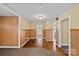 Open living room featuring hardwood flooring and classic paneled walls at 1000 Peachtree Rd, Charlotte, NC 28216