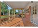 Covered porch with a porch swing, brick accents, and wood flooring at 1000 Peachtree Rd, Charlotte, NC 28216