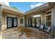Stone back patio with french doors, offering views of the outdoor space, and a serene view of the blue sky at 10502 Old Ardrey Kell Rd, Charlotte, NC 28277