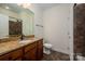 Standard bathroom with granite vanity, dark wood cabinets and decorative brown tile in the shower at 10502 Old Ardrey Kell Rd, Charlotte, NC 28277