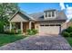 Charming home featuring stone accents, a well-manicured lawn, brick driveway and an attached two car garage at 10502 Old Ardrey Kell Rd, Charlotte, NC 28277