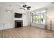 Bright living room with a decorative ceiling fan, fireplace, built-in cabinets and large windows for natural light at 10502 Old Ardrey Kell Rd, Charlotte, NC 28277