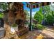 Inviting stone outdoor fireplace featuring artistic detail, flanked by lovely potted flowers and view of the serene backyard garden at 10502 Old Ardrey Kell Rd, Charlotte, NC 28277