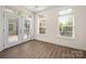 Cozy sunroom with large windows, modern flooring, and access to the outdoor deck at 10502 Old Ardrey Kell Rd, Charlotte, NC 28277