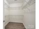 Spacious walk-in closet with metal shelving and wood-look flooring at 10502 Old Ardrey Kell Rd, Charlotte, NC 28277