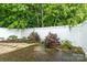 Private backyard offers a white fence, mature trees, and serene landscaping at 112 Dujon Ct, Mount Holly, NC 28120