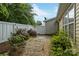 Backyard features gravel, a stone path, and greenery, with a white fence at 112 Dujon Ct, Mount Holly, NC 28120