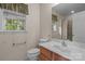Neutral bathroom featuring a single sink, and a window overlooking a green, wooded backyard at 112 Dujon Ct, Mount Holly, NC 28120