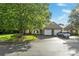 Street view showcasing the home's charming facade, attached garages, and lush landscaping at 112 Dujon Ct, Mount Holly, NC 28120