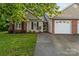 Inviting single-story home with attached two-car garage, black shutters, and a manicured lawn at 112 Dujon Ct, Mount Holly, NC 28120