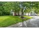 Street view of charming home with attached garages, mature trees, and a well-kept lawn at 112 Dujon Ct, Mount Holly, NC 28120