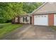 Charming brick and siding home featuring an attached garage and a well-maintained front lawn at 112 Dujon Ct, Mount Holly, NC 28120