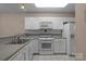 Bright kitchen featuring white cabinets, appliances, and tiled flooring for a clean, classic look at 112 Dujon Ct, Mount Holly, NC 28120