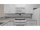 White kitchen with a range, microwave, and plenty of cabinet space at 112 Dujon Ct, Mount Holly, NC 28120