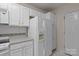 White kitchen featuring a range, refrigerator with water dispenser, and plenty of storage at 112 Dujon Ct, Mount Holly, NC 28120