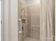 Close up of a tiled shower enclosure with safety bars and adjustable shower head at 112 Dujon Ct, Mount Holly, NC 28120