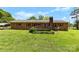 Well-manicured backyard featuring lush lawn and a classic brick home exterior with a cozy deck and privacy at 113 Helena St, Mount Holly, NC 28120