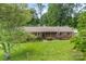 Lovely single-story brick home with a green lawn, mature trees and an American flag at 113 Helena St, Mount Holly, NC 28120