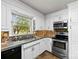 Well-lit kitchen featuring stainless steel appliances, modern backsplash, and white cabinetry at 113 Helena St, Mount Holly, NC 28120