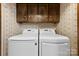 Bright laundry room featuring modern LG washer and dryer with overhead storage cabinets for optimal organization at 113 Helena St, Mount Holly, NC 28120