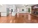 Open-concept living area with hardwood floors, brick fireplace, and seamless flow to the kitchen at 113 Helena St, Mount Holly, NC 28120