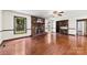 Bright living room featuring hardwood floors, brick fireplace, built-in shelving and abundant natural light at 113 Helena St, Mount Holly, NC 28120