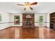 Well-lit living room with a brick fireplace, hardwood flooring, and a view to the outdoors at 113 Helena St, Mount Holly, NC 28120