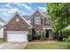 Beautiful two-story brick home featuring an attached two-car garage and a well-manicured lawn at 11526 Mcginns Trace Ct, Charlotte, NC 28277