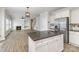 Open concept kitchen with island, stainless refrigerator, flows into the living room with fireplace at 11526 Mcginns Trace Ct, Charlotte, NC 28277