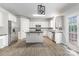 Modern kitchen with white cabinets, stainless steel appliances, an island, and hardwood floors at 11526 Mcginns Trace Ct, Charlotte, NC 28277