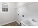 The laundry room features a utility sink, window, and vinyl flooring at 11526 Mcginns Trace Ct, Charlotte, NC 28277
