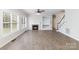 Open-concept living room featuring hardwood floors, a fireplace, and a large window at 11526 Mcginns Trace Ct, Charlotte, NC 28277