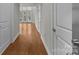 Inviting hallway showcasing sleek hardwood floors and neutral wall tones with multiple doors at 120F Steinbeck Way, Mooresville, NC 28117