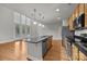 Modern open kitchen with granite island, wooden floors, stainless appliances and natural light at 120F Steinbeck Way, Mooresville, NC 28117