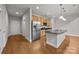Open kitchen with wood floors, stainless steel appliances, granite countertops and a stylish island at 120F Steinbeck Way, Mooresville, NC 28117