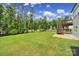 Lush green backyard featuring a deck with stairs and a wooded backdrop providing privacy at 13222 Fiore Pl, Huntersville, NC 28078