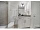 Modern bathroom featuring a vanity with storage, gray tile, and a well-lit mirror at 13222 Fiore Pl, Huntersville, NC 28078