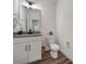 Bathroom with toilet, vanity, framed mirror, black faucet, basket, and flooring at 13222 Fiore Pl, Huntersville, NC 28078