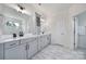 Bright bathroom featuring double sink vanity with grey cabinets and white countertops, and a tiled shower at 13222 Fiore Pl, Huntersville, NC 28078
