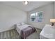 Bright bedroom with neutral carpet, a full bed, dresser, and large window at 13222 Fiore Pl, Huntersville, NC 28078