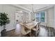 Elegant dining room with wainscoting, hardwood floors, a chandelier, and a large window at 13222 Fiore Pl, Huntersville, NC 28078