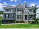 Charming two-story home featuring stone accents, a welcoming front porch, and well-maintained landscaping at 13222 Fiore Pl, Huntersville, NC 28078