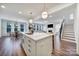 Open concept kitchen with a large island, dining area, and a view into the living room with a fireplace at 13222 Fiore Pl, Huntersville, NC 28078