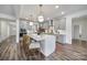 Bright kitchen featuring gray cabinets, a large central island with seating, and modern pendant lighting at 13222 Fiore Pl, Huntersville, NC 28078